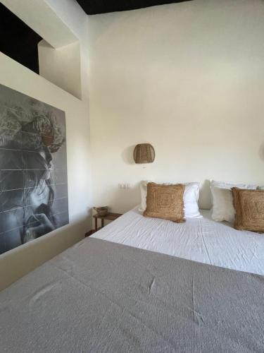 1 dormitorio con 1 cama con sábanas y almohadas blancas en Cortijo Rancho Verde, en Colmenar