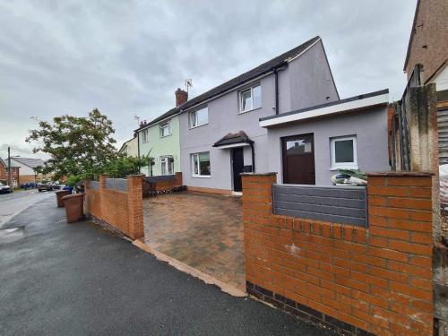 a house with a brick fence in front of it at Adina s House in Rugeley