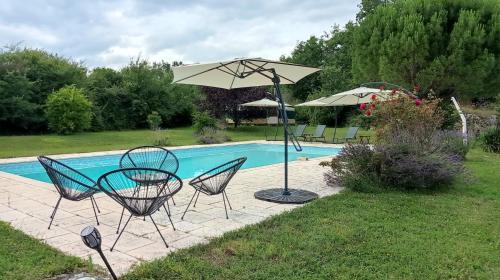- une table, des chaises et un parasol à côté de la piscine dans l'établissement Maison Oya, à Montréal