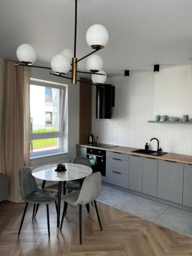 uma cozinha com uma mesa e cadeiras, uma mesa e uma janela em Apartament Szmaragdowy. em Siedlce
