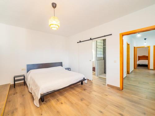 a white bedroom with a bed and a wooden floor at Cubo's The Secret Almogia Mountain View in Málaga