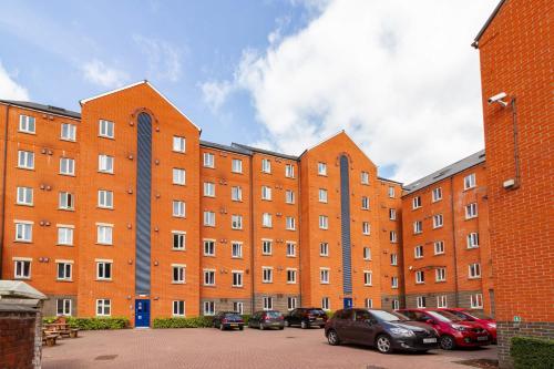 a large brick building with cars parked in a parking lot at For Students Only - Park Court in Lincoln in Lincoln