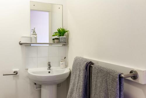 a white bathroom with a sink and a mirror at For Students Only - Park Court in Lincoln in Lincoln