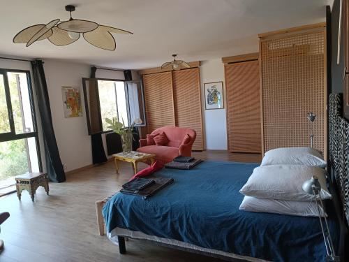 - une chambre avec un lit bleu et une chaise dans l'établissement Villa provençale et ses grands pins, à Pernes-les-Fontaines