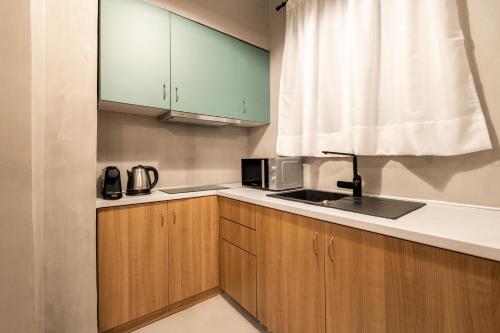 a kitchen with wooden cabinets and a sink and a window at Frinichou 18 by Athens Concept Residences in Athens