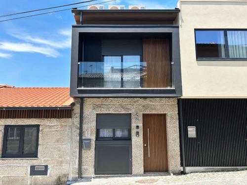 a brick house with a window and a door at Casinha da Arcela in Guimarães