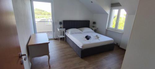 a bedroom with a bed and a table and two windows at Panoramic spacious 3 bedroom apartment in Sumartin