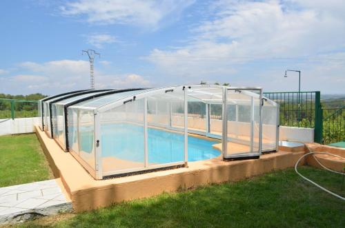 a swimming pool with a glass greenhouse around it at Casa rural en Casas de Moya 'Casa del Pino Gori' 