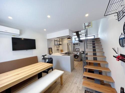 a living room with a staircase and a table and a kitchen at Casinha da Arcela in Guimarães