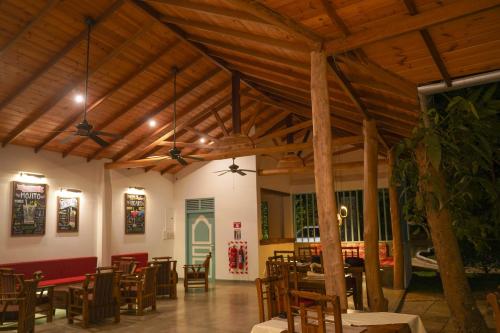 una sala da pranzo con soffitti e tavoli in legno e sedie di Kandalama Lodge a Dambulla