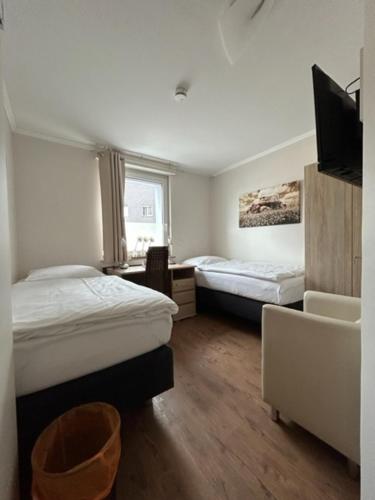 una camera con due letti e una televisione di Motel de Winter - Motel - Apartmenthaus - Monteurzimmer a Castrop-Rauxel
