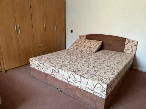 a bedroom with a bed with a wooden head board at Dom ALEX pri kúpalisku Thermalpark in Dunajská Streda