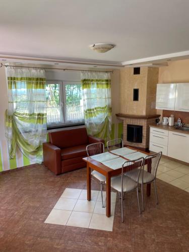 a kitchen and living room with a table and chairs at Villa Vip in Trzęsacz