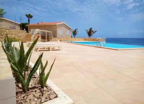 a resort with a swimming pool and the ocean at Casita Solemar direkt am Atlantik in Calheta Do Maio