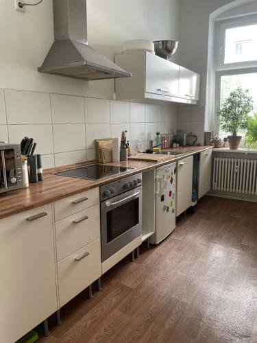 a kitchen with stainless steel appliances and wooden floors at 100qm Altbau Wohnung im Prenzlauer Berg in Berlin