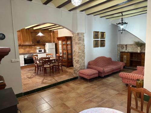 a kitchen and a living room with a table and chairs at Casa rural 'Villa Sarito' in Casas de Moya