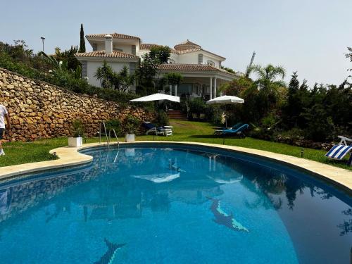 una gran piscina frente a una casa en VILLA MAIA Mijas Golf, en Santa Fe de los Boliches