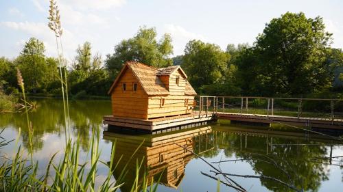 a small wooden house sitting on top of a lake at Les Cabanes Flottantes in Givrauval