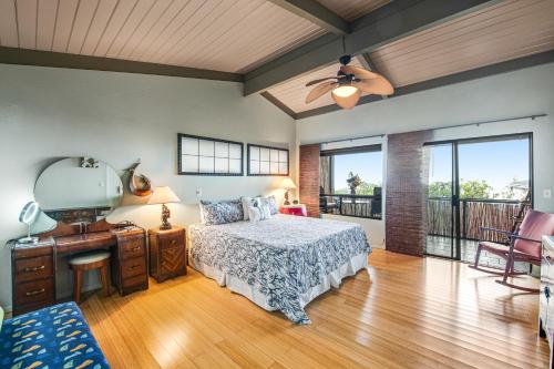 a bedroom with a bed and a desk with a fan at Koana Oasis in Kailua-Kona