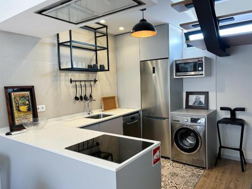 a kitchen with a sink and a washing machine at Casinha da Arcela in Guimarães