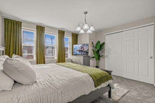 a bedroom with a bed and a tv and windows at Uptown Gem! 2Luxe King Suites - 5 Smart TV's - Parking in Philadelphia