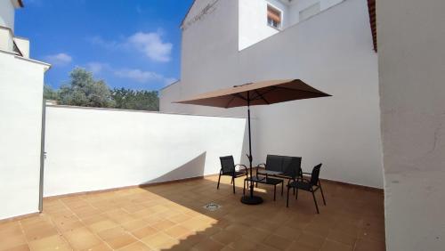 une terrasse avec une table, des chaises et un parasol dans l'établissement Cuchillos de la fonseca, 