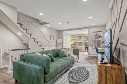 a living room with a green couch and a staircase at Uptown Gem! Immaculate-Comfort-Character! in Philadelphia
