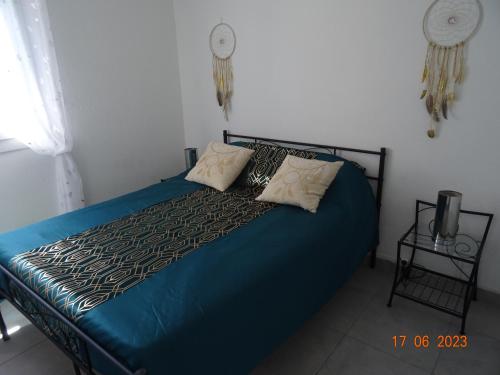 una camera con letto blu e 2 cuscini di Appartement cosy à 500m de la mer a Plage dʼArgelès