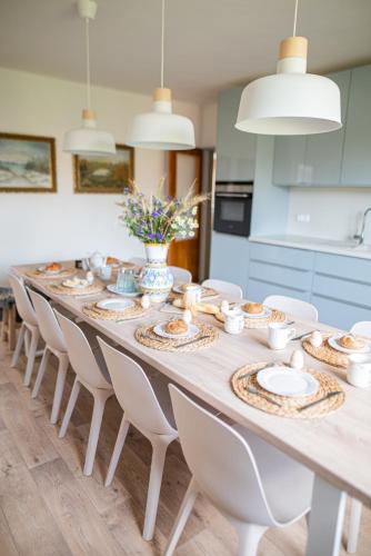 a long dining room table with white chairs and plates at Chalupa Morava in Veselí nad Moravou