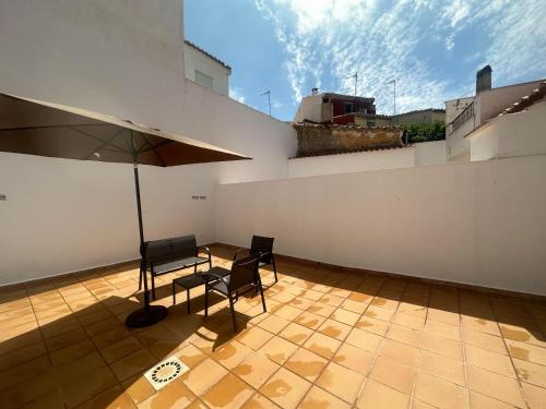 un patio con 2 sillas y una sombrilla en el techo en Flat 'Hoces del Cabriel' in Casas de Moya, 