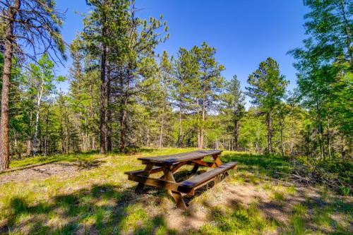 a picnic table in the middle of a field at Sunny Forest Cabin with Views of Pikes Peak Mtn! in Florissant