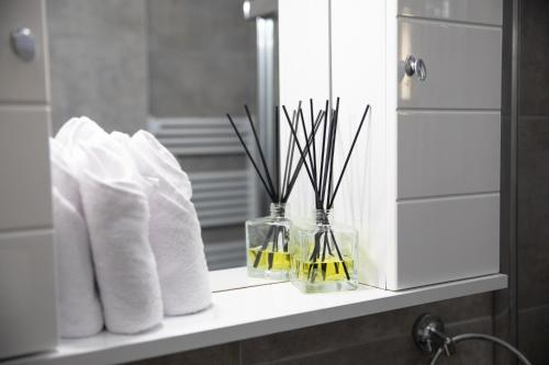 a bathroom counter with towels and flowers in a mirror at Glamorous, Renovated 3-Bedroom Apt in Nicosia in Nicosia