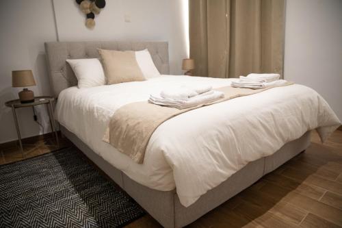 a bedroom with a large white bed with towels on it at Glamorous, Renovated 3-Bedroom Apt in Nicosia in Nicosia