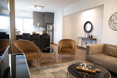 a living room with a couch and chairs and a kitchen at Glamorous, Renovated 3-Bedroom Apt in Nicosia in Nicosia