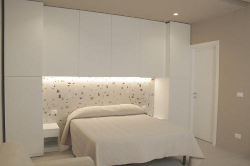 a bedroom with a bed and a white wall at Casa Vacanze Mariantò in Noci