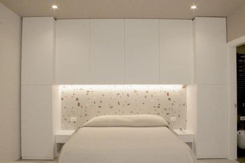 a bedroom with a bed and white cabinets at Casa Vacanze Mariantò in Noci