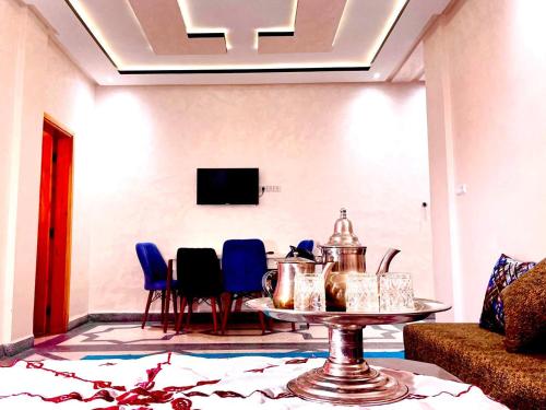 un soggiorno con tavolo, sedie e TV di Résidence Othmane a Dakhla