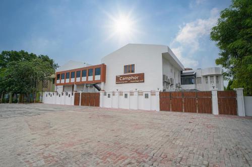 a white building with a fence in front of it at TPC Camphor in Tiruchchirāppalli