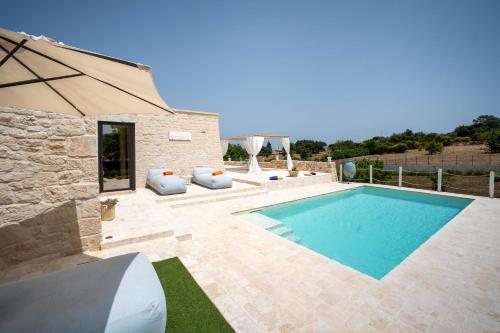 マルティナ・フランカにあるWePuglia - Trullo Meravigliosoのスイミングプールとパティオ付きのヴィラ