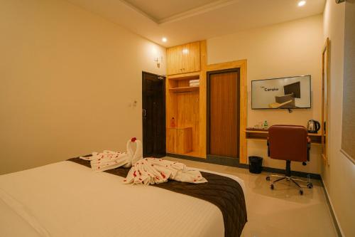 a bedroom with a bed and a desk and a chair at TPC Camphor in Tiruchchirāppalli