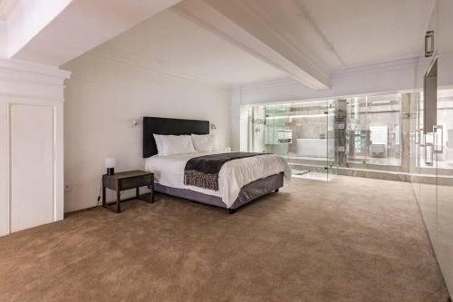 a large bedroom with a bed and a large window at Ultra Luxury 3 Bedroom Address on Adderley in Cape Town