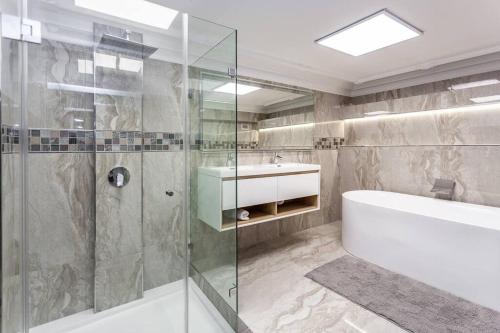 a bathroom with a shower and a tub and a sink at Ultra Luxury 3 Bedroom Address on Adderley in Cape Town