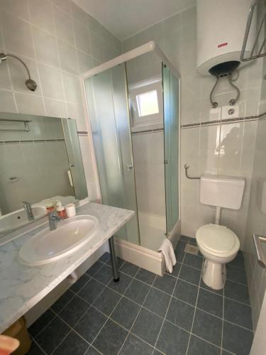 a bathroom with a sink and a toilet and a shower at Apartments Olea in Rab