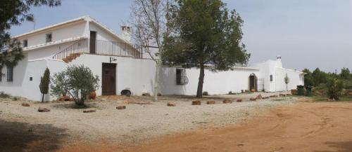 ein weißes Haus mit einer Schotterstraße davor in der Unterkunft Gran Casa, Lagunas de Ruidera, BBQ, porche, chimenea in Ruidera