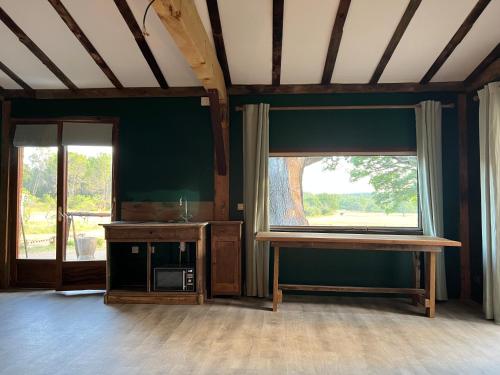 Zimmer mit einem Fenster, einem Tisch und einer Mikrowelle in der Unterkunft La cabane de babarot in Aups