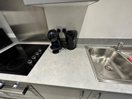 a kitchen counter with a sink next to a sink at Cosy MCR 1 Bed Apt with Balcony in Manchester