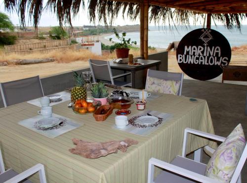 a table with food on it with the beach in the background at Marina Bungalows in Los Órganos