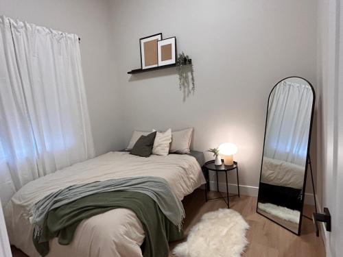 a small bedroom with a bed and a mirror at Cozy and Adorable Tiny House - Near PDX! in Vancouver