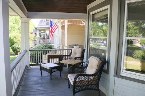 a porch with chairs and a table with an american flag at Historic Home with Outdoor Hot Tub Near Downtown in Public Transportation Hub in Chicago