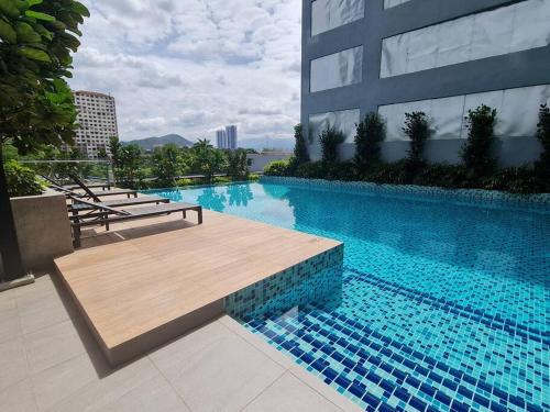 uma grande piscina com um banco de madeira ao lado de um edifício em Contemporary 2R2B Studio 10 minutes from KLCC em Kuala Lumpur